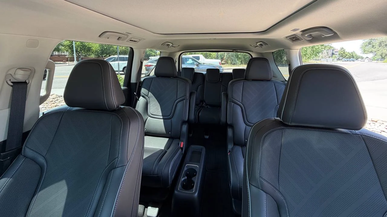 Dark passenger cabin with separate second-row seats in the INFINITI QX80