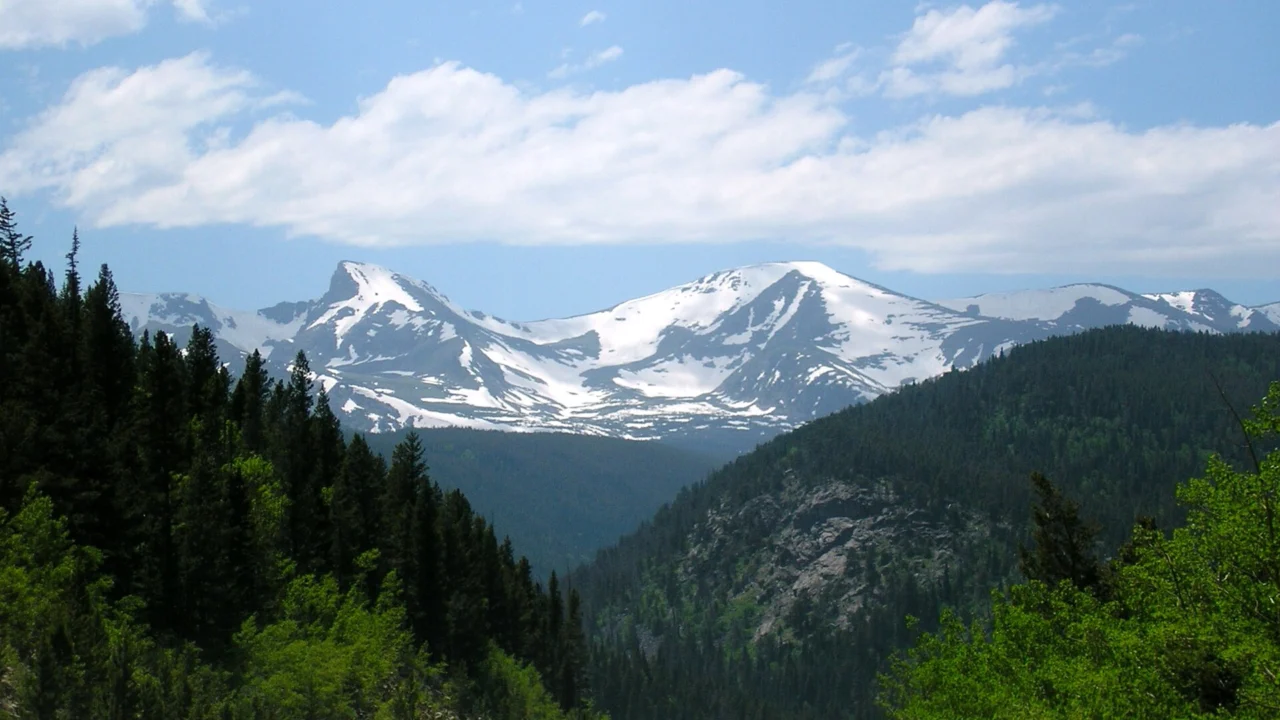 Snow-covered Colorado Rocky Mountains above a forested valley